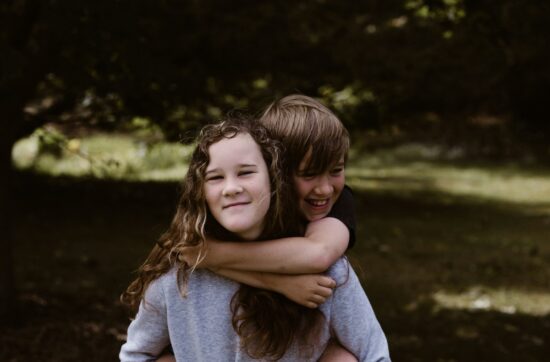 boy riding girl's back during day